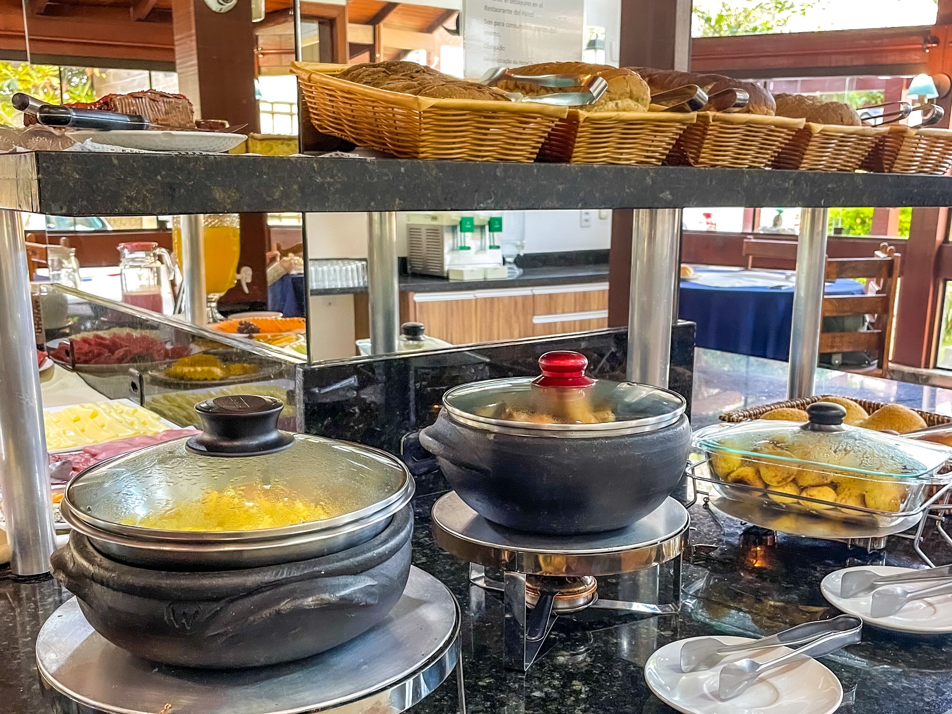Uma área de buffet com diversos alimentos e utensílios.