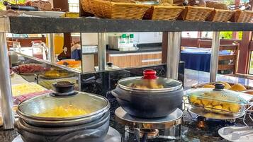 Uma área de buffet com diversos alimentos e utensílios.