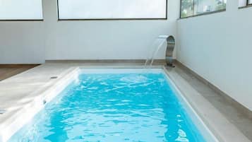 Una piscina al aire libre, sillones reclinables de piscina