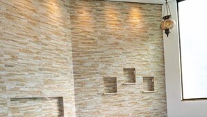 A modern spa room with a large hot tub, stone wall, and recessed lighting. - Hotel e Pousada Sonho Meu (Florianópolis)