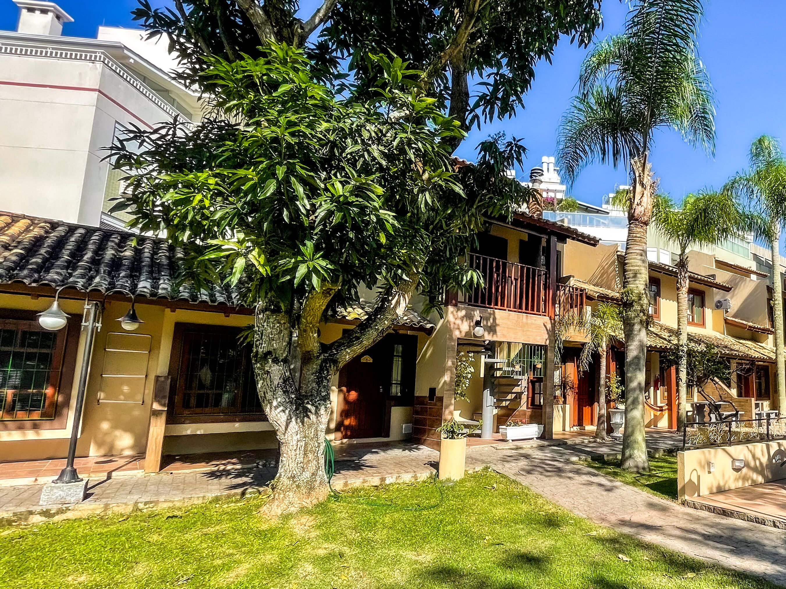 A residential area with a tree-lined street, traditional architecture, and a clear blue sky.