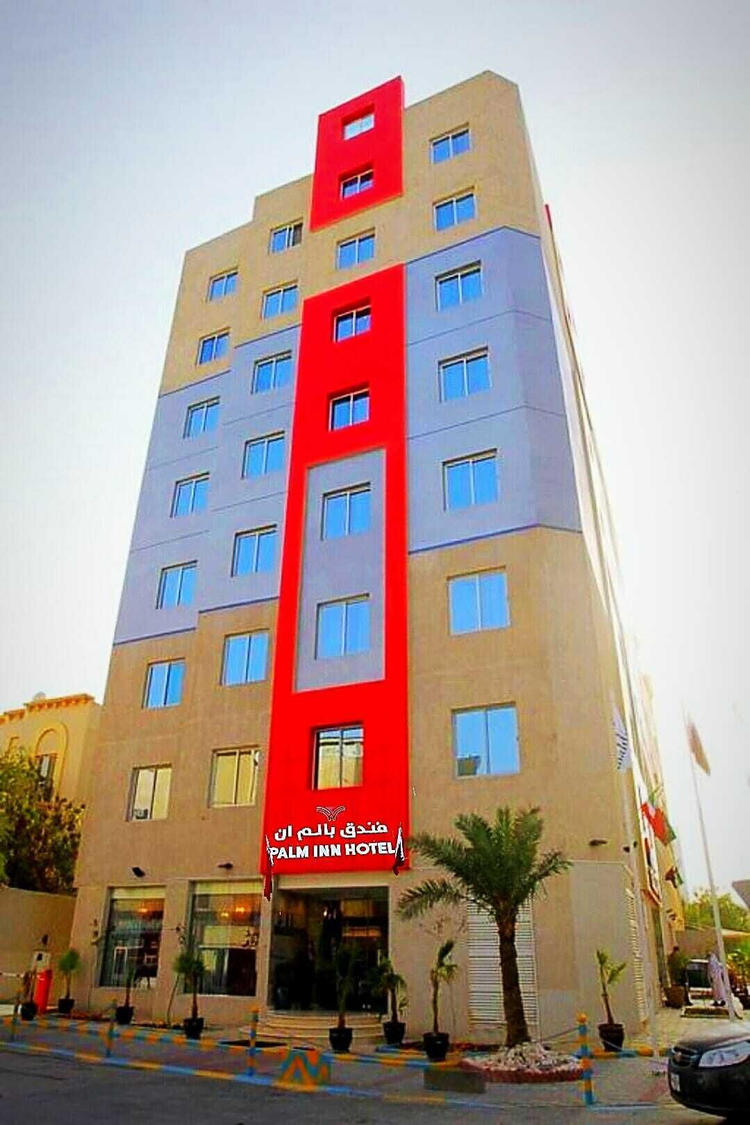 Um hotel com várias andares e uma faixa vertical vermelha marcante na fachada.