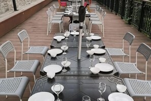Un área de comedor al aire libre con mesas y sillas dispuestas para los huéspedes.