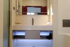 A bathroom with a mirror, a sink, and a towel rack.