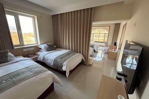 A hotel room with two beds, a TV, a desk, and a view of the outdoors. - Haiyi Hotel Xueye (Jinan)