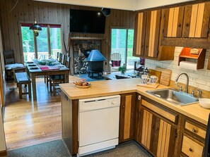 A kitchen with wooden cabinets, a built-in oven, and a dining area with a table and chairs.