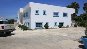 A white building with blue trim and multiple windows. - Complejo Ecoturistico Rancho Cielo (Licey al Medio)