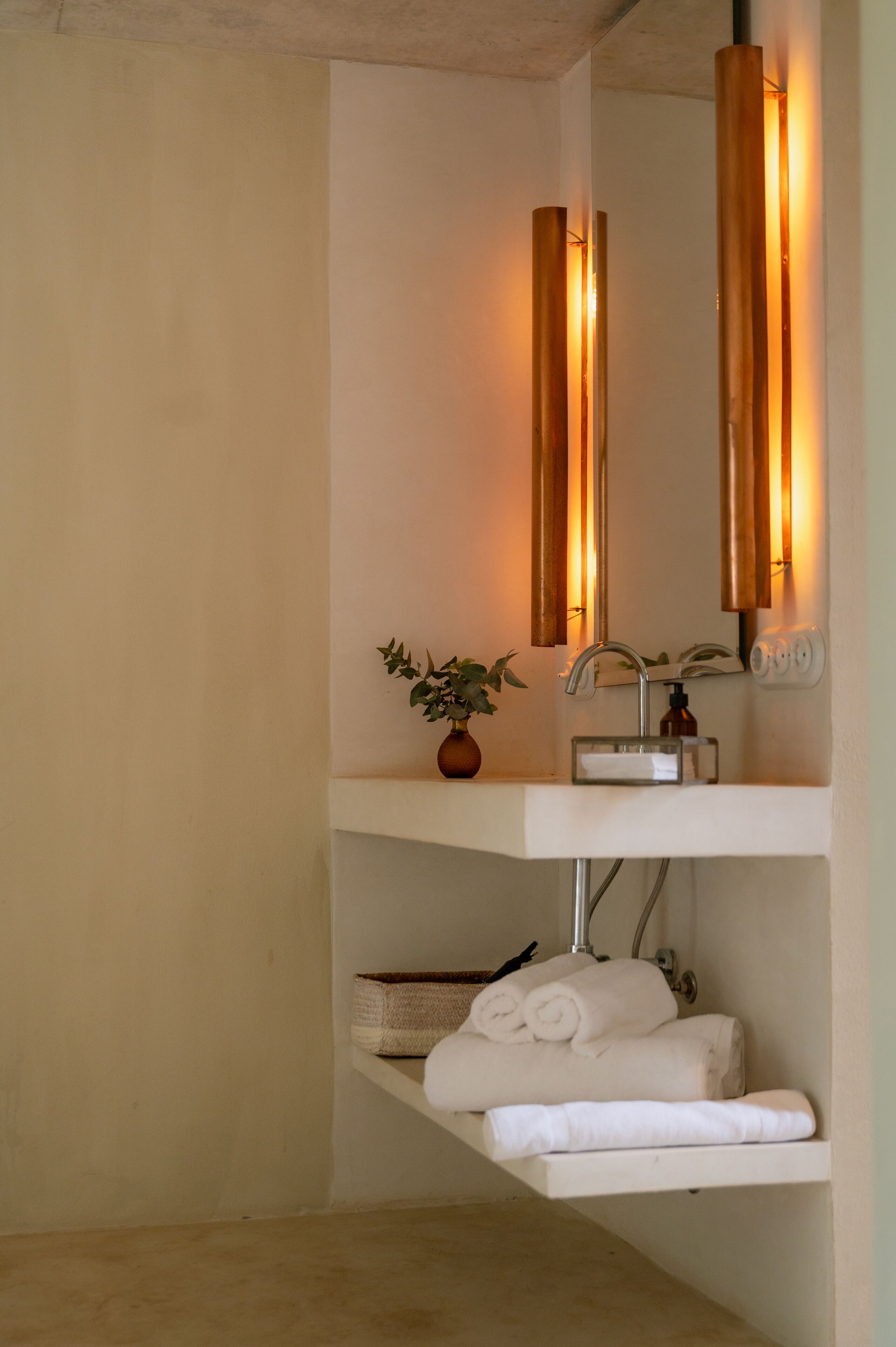 A bathroom with a white sink, a mirror, and a towel rack.