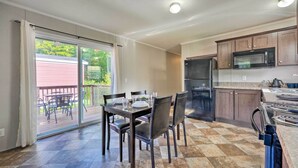 A kitchen with a dining area, a refrigerator, a microwave, and a sliding glass door to a patio. - Pet-Friendly Cassolopis Escape, Near Lake! (Cassopolis)