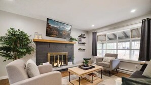 A modern living room with a fireplace, comfortable seating, and large windows. - Heart of Pocono Mountains - Huge Yard - Game Rm <10 min to Kalahari & Casino (Mount Pocono)
