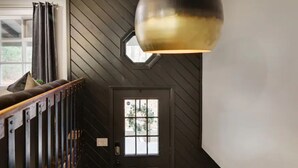 A staircase with wooden railings and a black door with a window. - Heart of Pocono Mountains - Huge Yard - Game Rm <10 min to Kalahari & Casino (Mount Pocono)