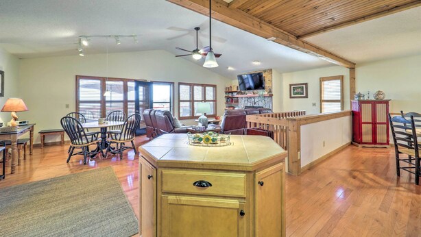 A spacious living area with a wooden ceiling, a dining table with chairs, a kitchen island, and a TV mounted on the wall. - Mtn-View Cabin w/ Deck, 2 Mi to Beech Mtn Slopes! (Beech Mountain)
