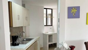 A modern kitchen with light wood cabinets, a built-in oven, and a coffee maker. - Modern Apt With View of the Basilica (Guadalajara de Buga)