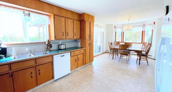 Enjoy meals in the kitchen with dishwasher and adjacent dining area with wooden table and chairs.