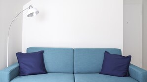 A light blue sofa with two dark blue pillows and a floor lamp. - Giuseppe Pastine 17 D - Santa Margherita Ligure (Santa Margherita Ligure)