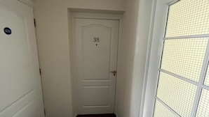 A white door with the number 38, a small sign on the left, and a window with a grid pattern on the right. - Stunning 3-bed Apartment in Croydon (Croydon)