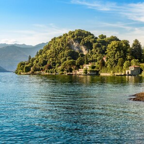 A lake with a small island covered in trees and houses. - Casa Amabile With Pool (Leggiuno)