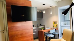 A modern kitchen with a built-in TV, wooden cabinetry, and pendant lighting. - Av0806 Studio Avanhandava (São Paulo)
