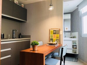 A modern kitchen with a wooden island, a potted plant, and a bulletin board with motivational quotes. - Av0806 Studio Avanhandava (São Paulo)