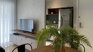 A modern kitchen with a built-in refrigerator, a wooden countertop, and a television on a cabinet. - Hype055 in S o Paulo (São Paulo)