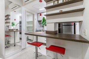 A modern kitchen with a built-in refrigerator, a wooden countertop, and a red bar stool. - Av0108 in S o Paulo (São Paulo)