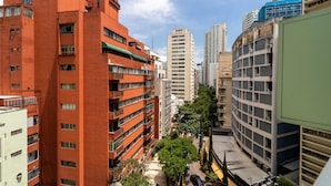 A multi-story building with balconies and a parking area in the foreground. - Av0703 Studio Avanhandava (São Paulo)