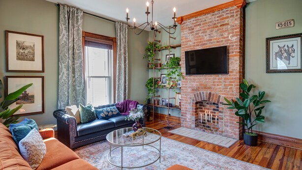Una sala de estar acogedora con chimenea de ladrillo, un sofá de cuero y una mesa de centro.