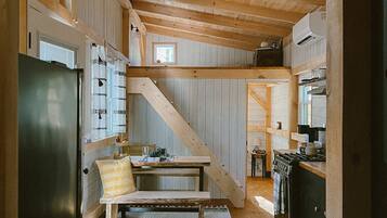 Un intérieur rustique en bois comprenant une cuisine, un coin repas et un escalier.