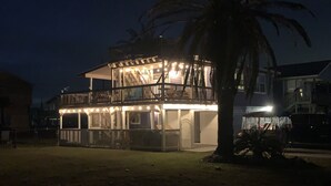 Ein zweistöckiges Gebäude mit Balkon und überdachtem Außenbereich, umgeben von anderen Häusern.