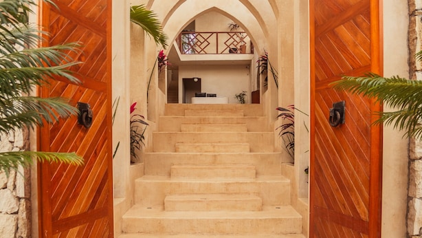 A grand entrance with a series of arched doorways leading to a staircase. - BACALARI HOTEL BOUTIQUE (Bacalar)