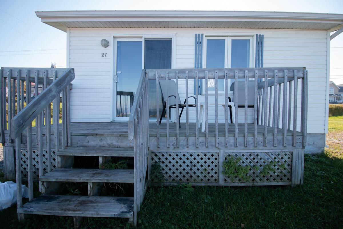 A single-story house with a porch, a door, and a window.