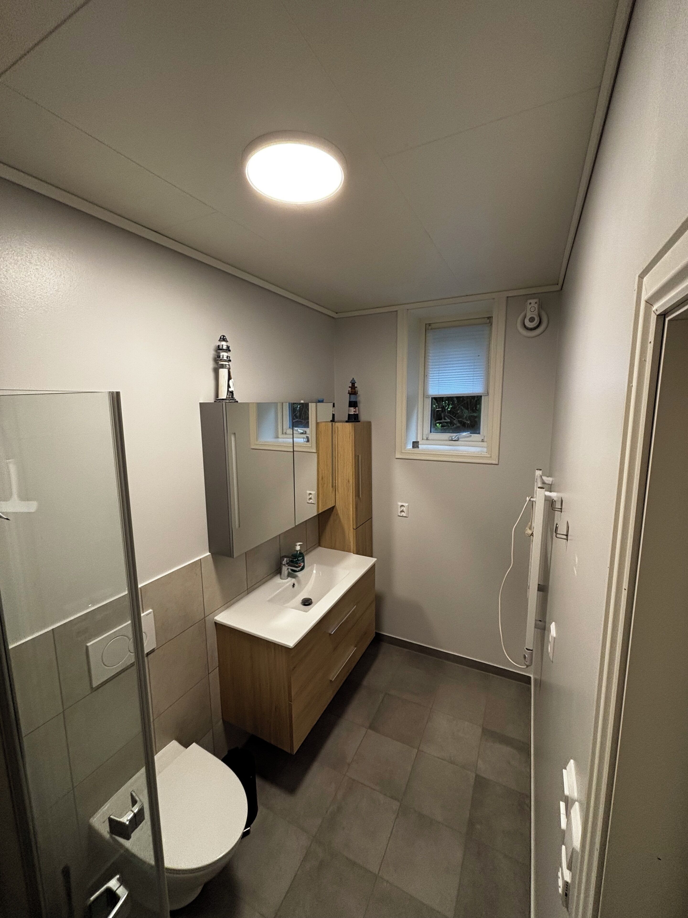 Ein modernes Badezimmer mit Toilette, Waschbecken und Spiegel.