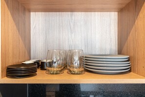 A wooden cabinet with stacked plates and glasses.
