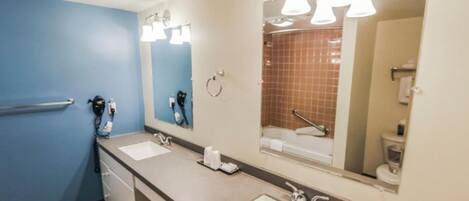A bathroom with two sinks, a mirror, and a shower area.