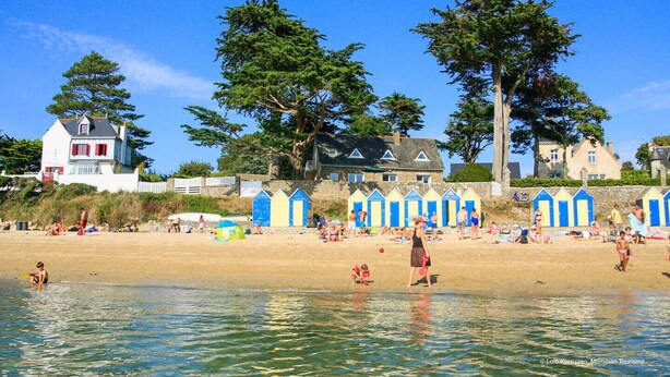 A beach with beach huts, a sandy shore, and a few people. - Comfortable 3* house with swimming pool (Larmor-Baden)