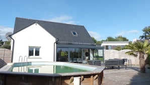 A house with a swimming pool, a covered patio, and a wooden deck. - Comfortable 3* house with swimming pool (Larmor-Baden)