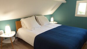 Un dormitorio con cama, dos mesitas de noche y una ventana.