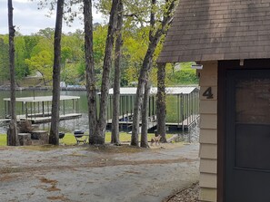 A lakeside cabin with a dock, surrounded by trees and a view of the water.