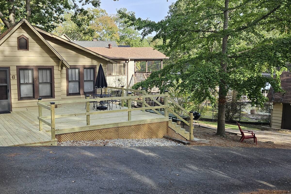 A two-story house with a wooden deck and a covered porch.