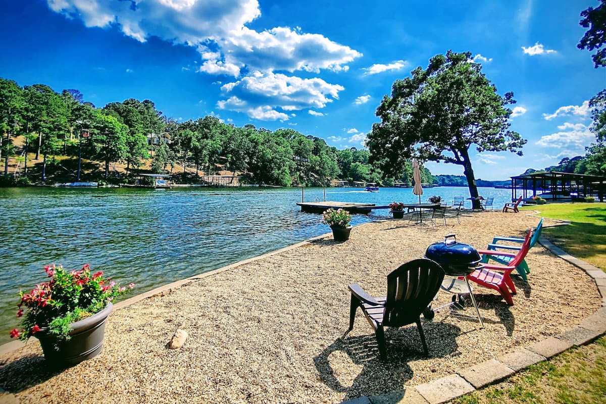 A lakeside park with a dock, chairs, and a gazebo.
