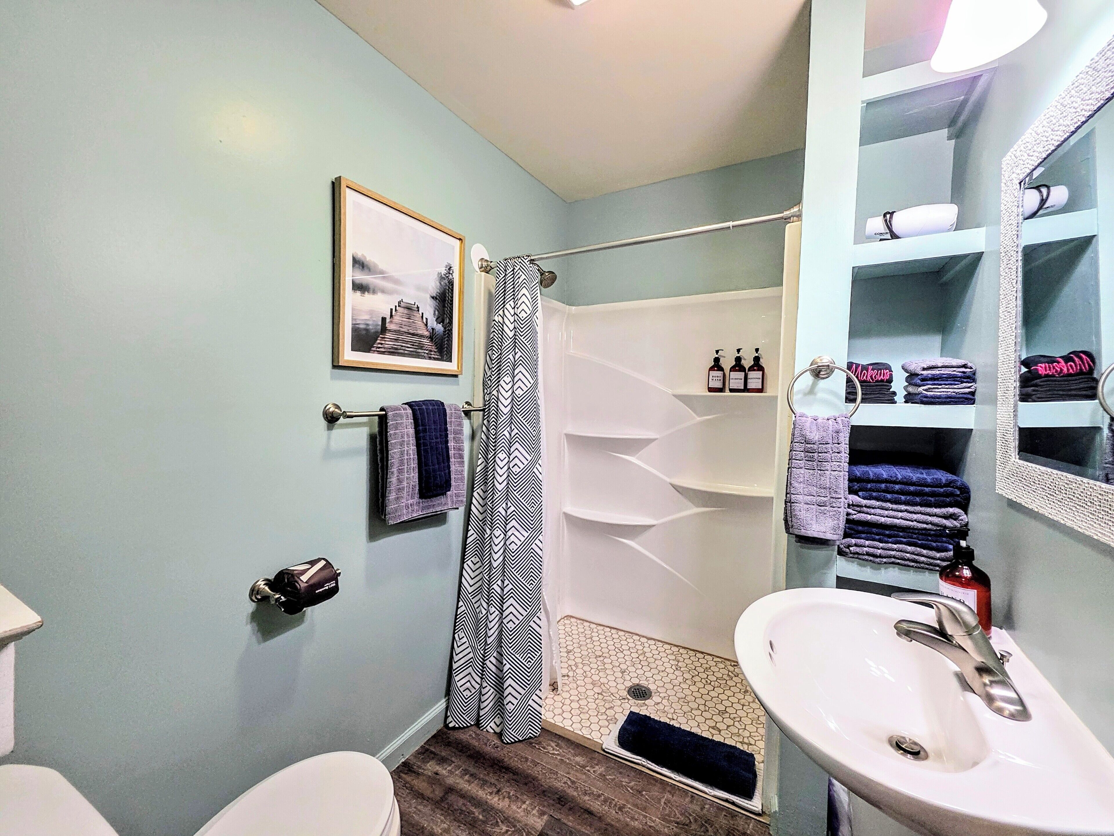 Un baño con inodoro, lavamanos, ducha y toallero.