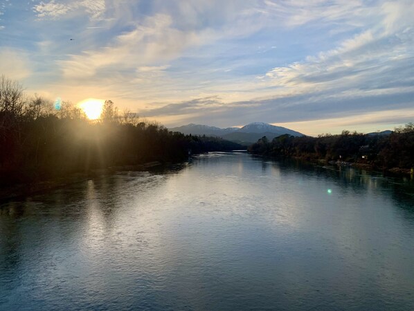 Un río con montañas al fondo y un cielo despejado.