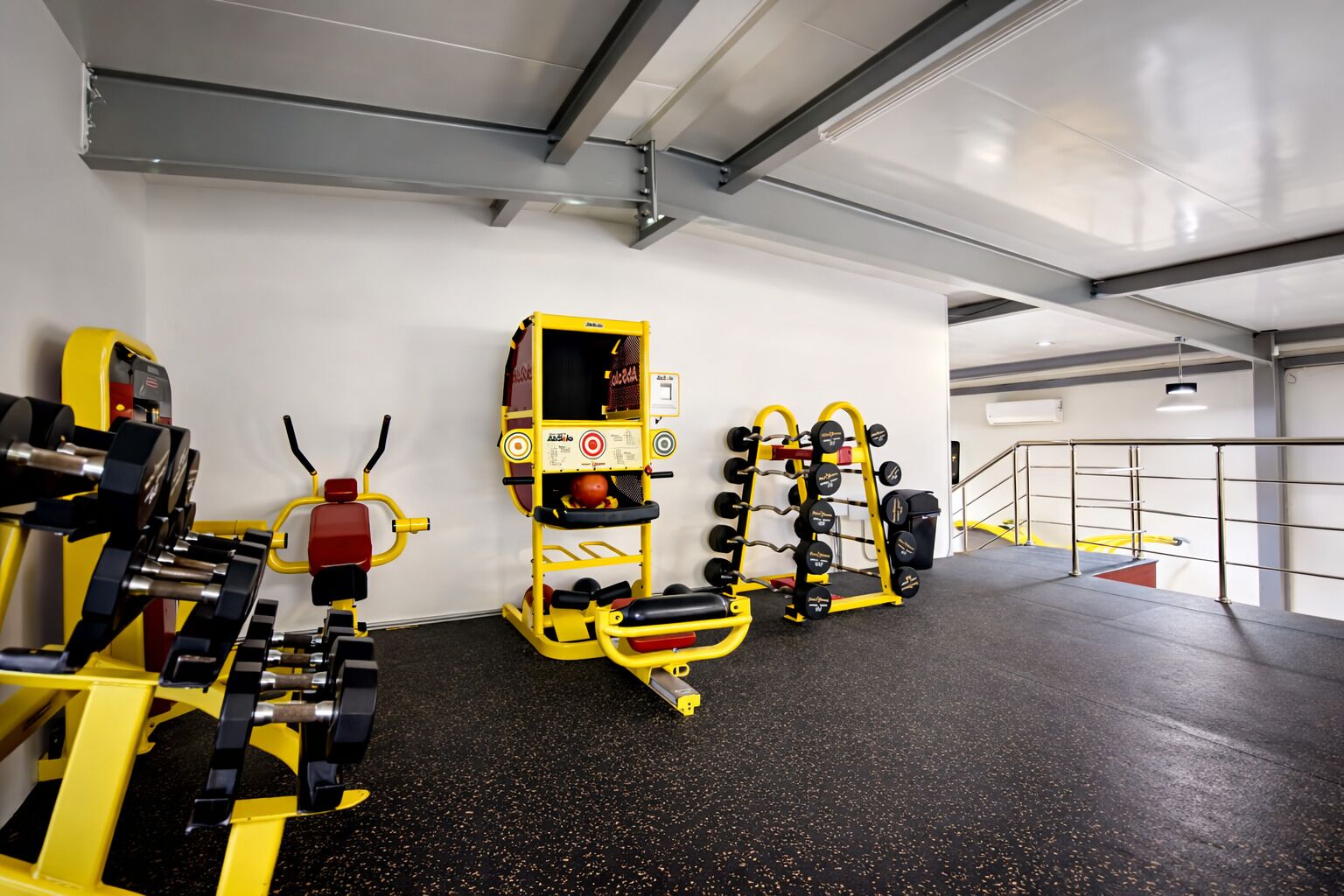 A gym with weightlifting equipment, a bench press, and a squat rack.