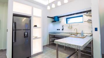 A modern kitchen with a stainless steel refrigerator, granite countertops, and a built-in oven.