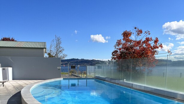 Una piscina con vistas despejadas al lago y a las montañas de fondo.