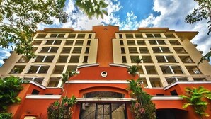 Un hotel de varios pisos con un atrio central, amplias ventanas y una entrada destacada.