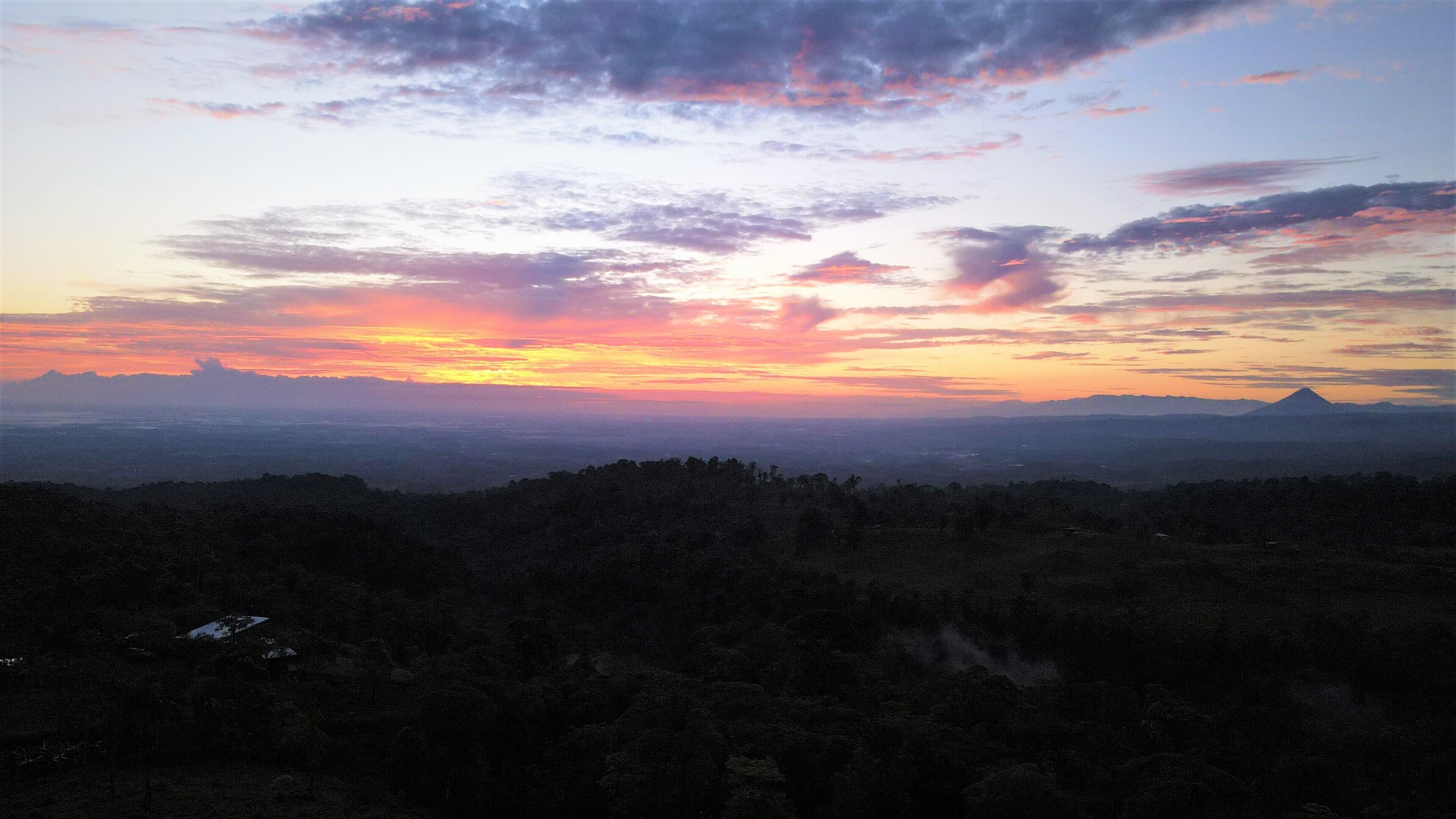 A landscape view of a mountainous area with a sunset.
