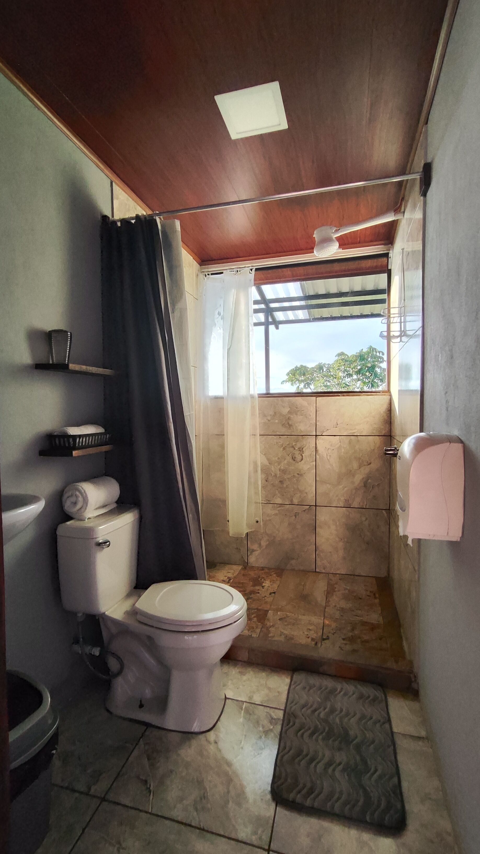 Un baño pequeño con inodoro, ducha y lavamanos.