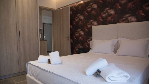 Une chambre d’hôtel avec un grand lit, une armoire et un miroir.