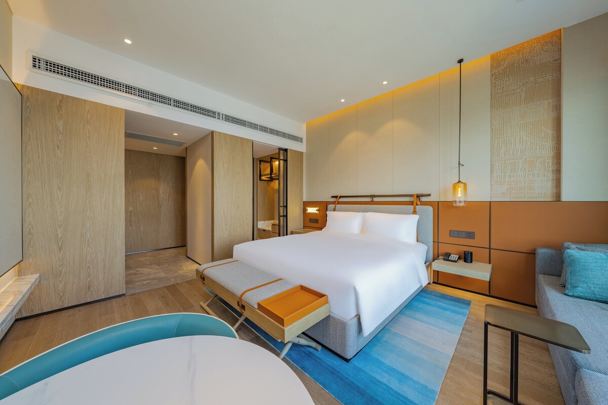 Een moderne hotelkamer met een groot bed, een bureau en een zithoek.
